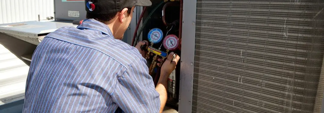 HVAC technician servicing a condenser unit in Lynchburg, Moore County