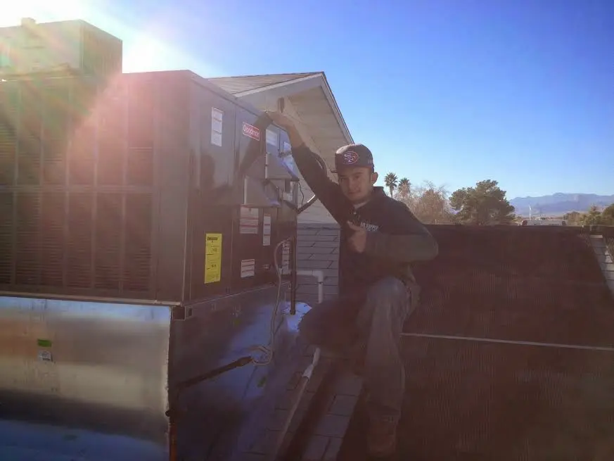 HVAC technician performing AC Tune-Up on a rooftop unit in Lynchburg, Moore County